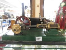 A Stuart Turner steam engine with cylinder and motion wheel.