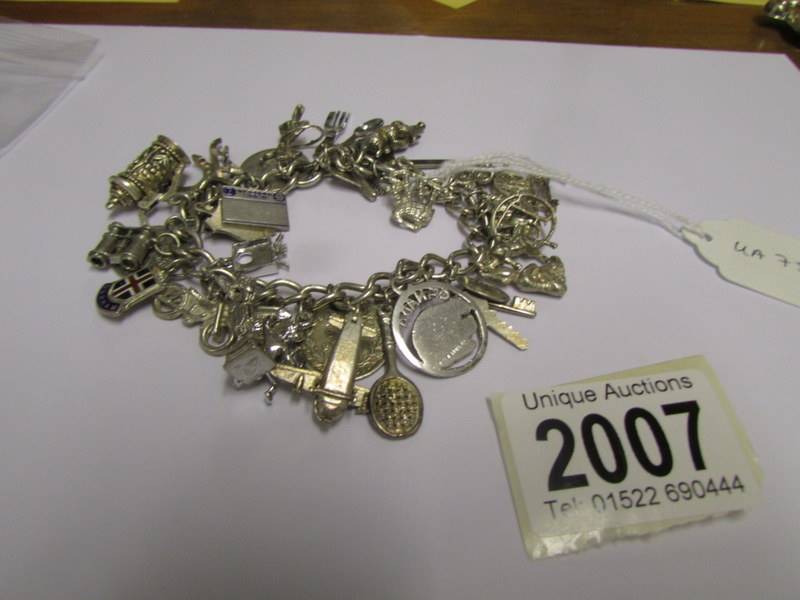 A silver charm bracelet with approximately 30 charms (5 marked 925 the rest not marked).
