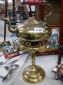 An early 20th century brass kettle on stand with cranberry glass handle