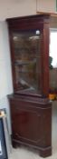 A dark wood stained corner cupboard with cut glass door panel 70 cm x 49cm x height 184 cm.