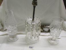 A cut glass table lamp with droppers and two cut glass candle lamps.