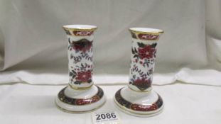 A pair of Royal Worcester porcelain candelsticks.