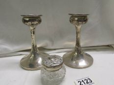 A pair of silver candlestick and a glass trinket pot with silver lid (lid a/f.)