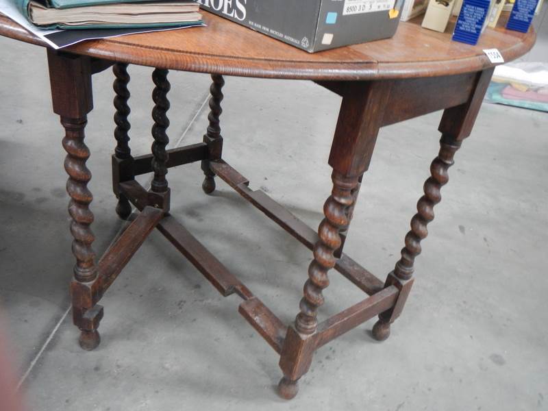 A mid 20th century oak barley twist gate leg table. COLLECT ONLY.