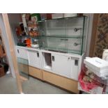 A pair of commercial display cabinets, top half glass with lights and bottom half wood storage