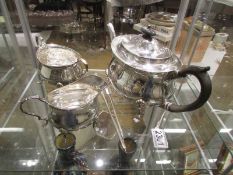 A three piece silver plate tea set and two other items.