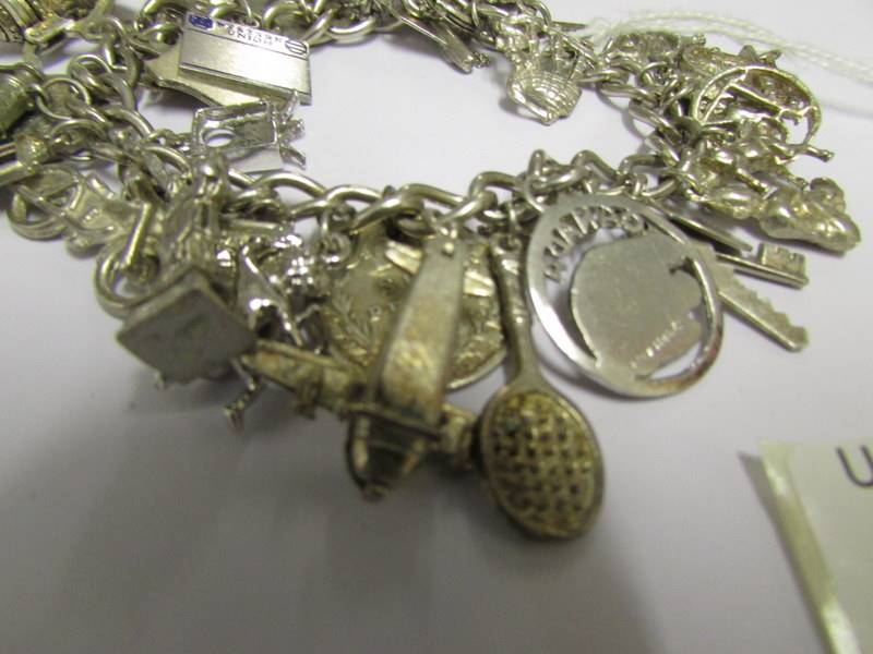 A silver charm bracelet with approximately 30 charms (5 marked 925 the rest not marked). - Image 2 of 3