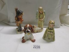 A Goebel dog, a Goebel boy with cello, A Gobel Angel with baby Jesus and another Goebel figure.