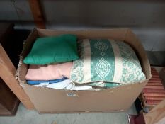 A box of blankets, cushions, cardigans etc.