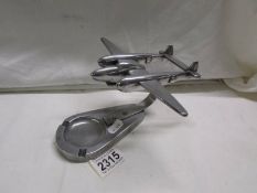 A silver plate ashtray surmounted aircraft.