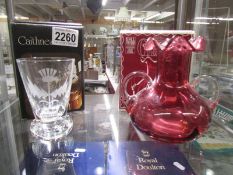 A boxed Caithness engraved vase and a boxed cranberry glass twin handled vase. Collect Only.