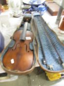 An old violin with two bows and in a wooden case.