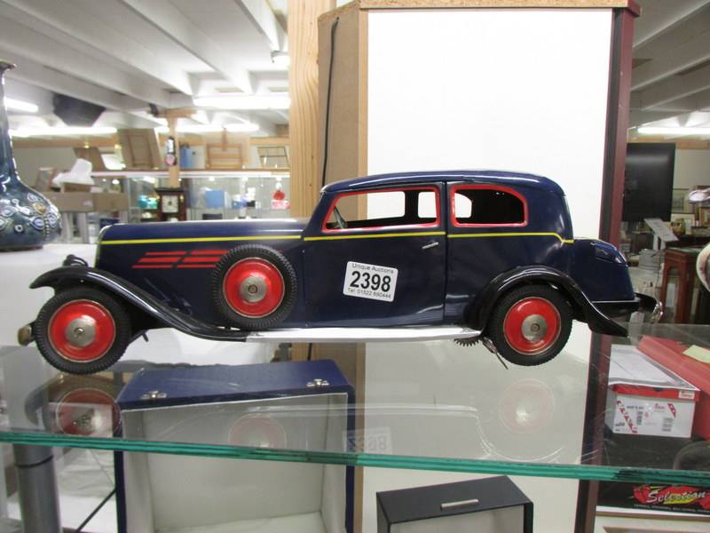 A large tinplate clockwork 1930's style car with opening doors and boot, 50 cm long.