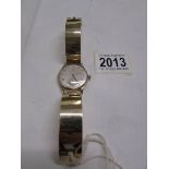 A 9ct gold Omega wrist watch on a 9ct gold strap, in working order.