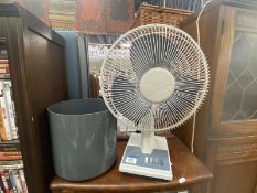 An electric fan and a plastic waste paper bin