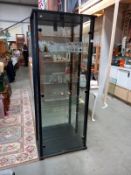 A mirror backed glass display case with wood frame and glass shelves (68cm x 36cm x 171cm height)