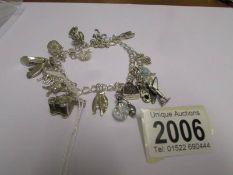 A silver charm bracelet with 18 charms (5 marked 925 the rest not marked).