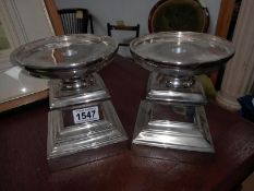 A pair of short white metal candle stands