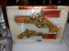 2 pistol shaped whisky bottles