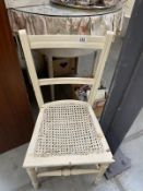 A white ladder back kitchen chair with bergere seat