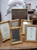 A quantity of gilded photo frames.