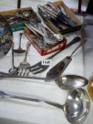 A collection of silver plate cutlery including ladle