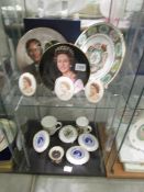 Two shelves of commemorative items including Prince William plate, 40th anniversary plate etc.,