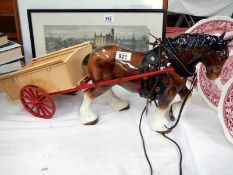 A large brown horse pulling a 2 wheel cart