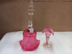 A large cranberry glass bell with clear handle and a spill vase