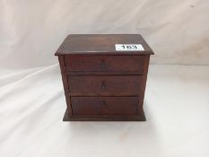 A miniature dark oak chest of drawers 14cm x 9cm x 12cm