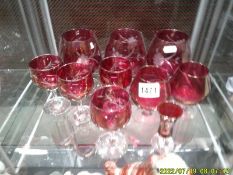 Five red glass brandy goblets and 5 other red glasses.