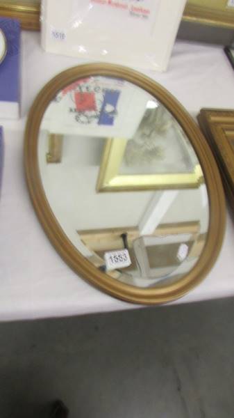 An oval framed bevel edged mirror. COLLECT ONLY.