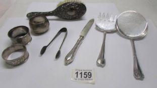 Eight items of silver including napkin rings, flatware, silver backed hair brush etc.,