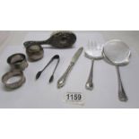 Eight items of silver including napkin rings, flatware, silver backed hair brush etc.,