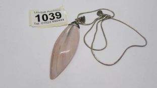 A pink stone pendant necklace.