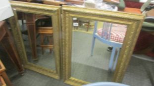 A pair of gilt framed bevel edged mirrors.