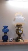 A brass table lmap with glass shade and a blue glass oil lamp.