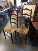 A pair of ladderback chairs with reed seats