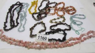 A tray of assorted stone necklaces and bracelets.