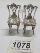A pair of silver doll house chairs, 20 grams.