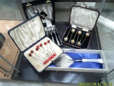 A cased set of cake forks, cased set of coffee spoons, cocktail sticks and cake slice.