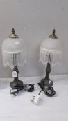 A pair of table lamps with beaded shades.