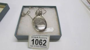 A silver locket on chain, 21 grams.