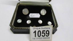 A cased set of silver and mother of pearl cuff links and studs.