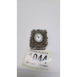 A miniature silver clock.