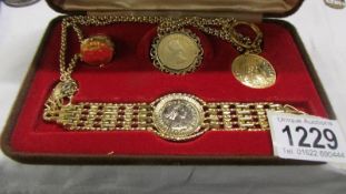 A cased coin set including pendant, bracelet, ring and key ring.