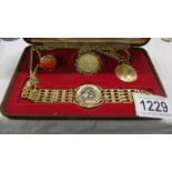 A cased coin set including pendant, bracelet, ring and key ring.