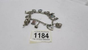 A charm bracelet dated 1958 Birmingham in silver with 12 silver charms including Lincoln Imp,