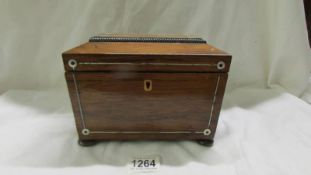 A 19th century mahogany tea caddy inlaid with mother of pearl.