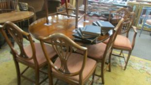 A circular mahogany dining table and a set of six chairs. COLLECT ONLY.